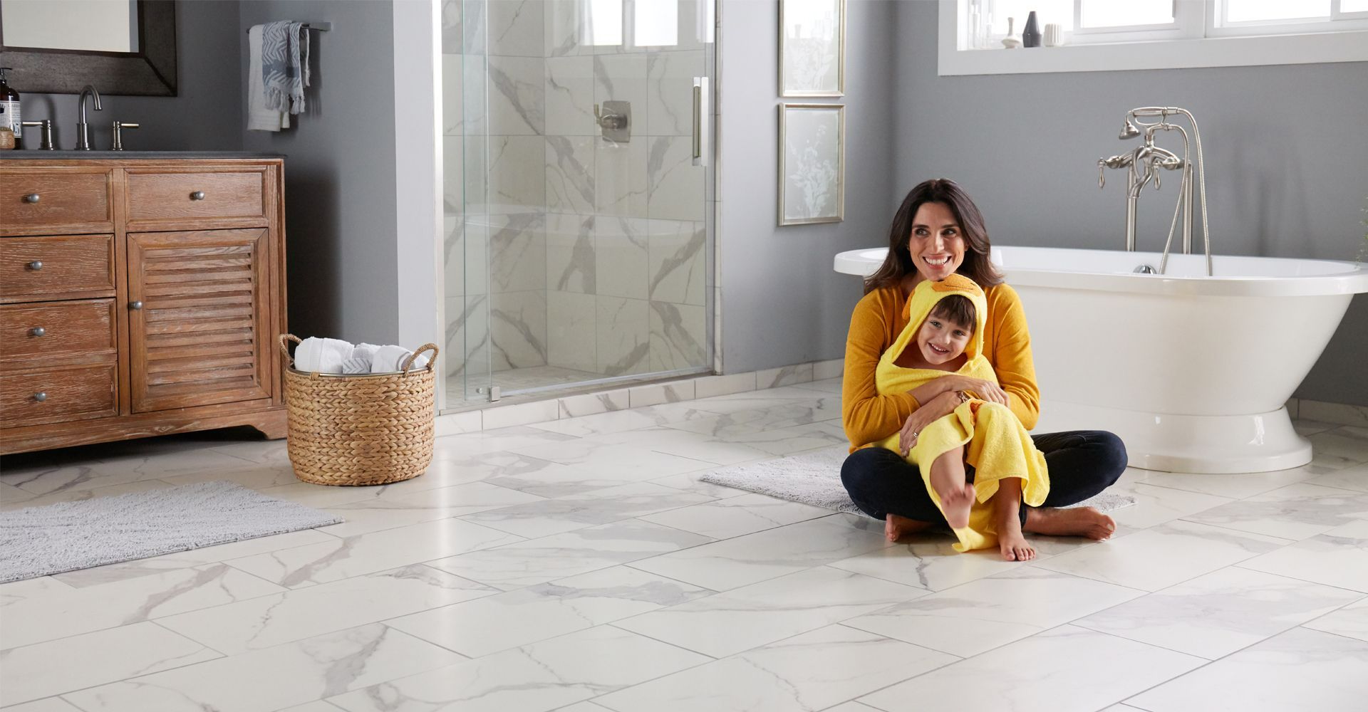 Woman sitting on hardwood floors with small dog next to her